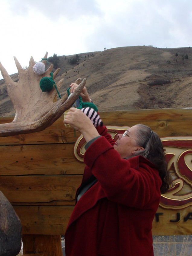 woman embellishing moose sculpture