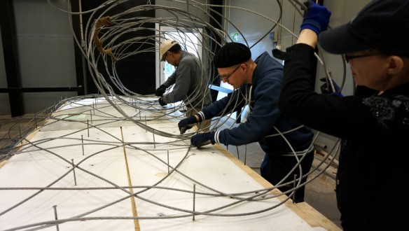 people working on large wire lace